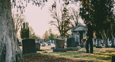Homme devant une tombe dans un cimetière